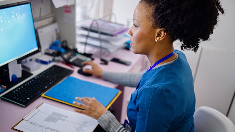 Healthcare professional using a desktop computer.