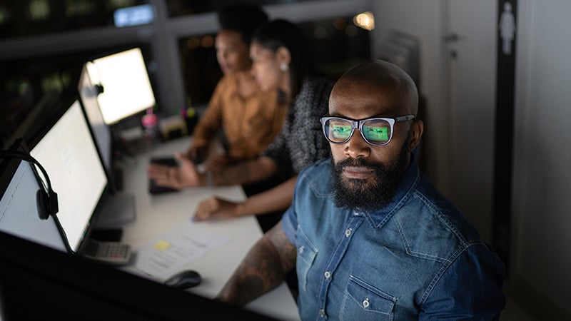 SOC analyst sits at a computer screen triaging alerts.